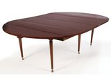 La table est en bois et son plateau est en cuir marron.
