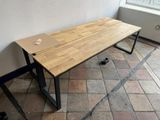 a wooden table that is sitting on a brick floor
