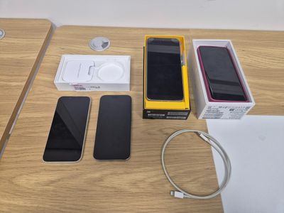 a table with a phone, headphones, and a charger on it