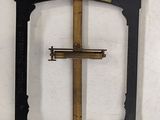 a cross in the middle of a black and gold frame