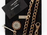 an assortment of jewelry including a gold chain, a coin, and a key