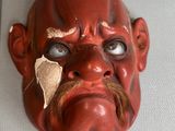 un masque rouge accroché au mur d'une pièce