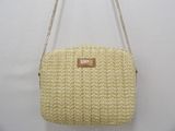 beige straw purse with chain strap and name tag on it