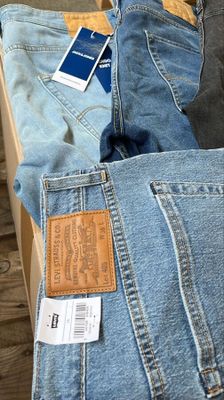plusieurs paires de jeans sont empilées les unes sur les autres