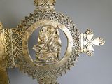 a gold cross with a picture of a woman on it