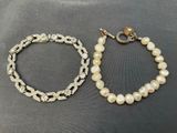 a close up of two bracelets with pearls on a table