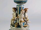 un vase bleu et blanc orné d'anges et de cerises
