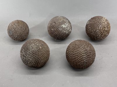 quatre boules métalliques posées les unes à côté des autres sur une table
