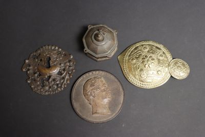 three antique brass buttons and a coin on a black surface