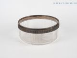 a glass jar with a silver lid on a white surface