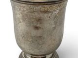 a silver cup on a pedestal on a white background