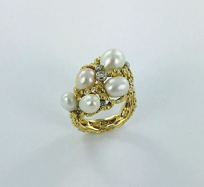un gros plan d'une bague ornée de perles et de diamants