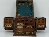un petit coffre en bois à trois tiroirs, surmonté d'un miroir