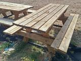 deux tables de pique-nique en bois posées dans l'herbe