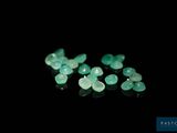 a close up of a group of green gems on a black surface