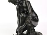 une image représentant la statue d'un homme à genoux sur fond blanc