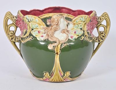 un vase vert sur lequel est représentée une femme