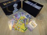 a box of pokemon cards sitting on a table next to a box of cards