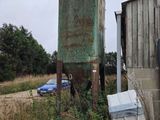 a blue car parked in front of a rusted out building