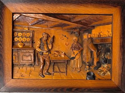 des sculptures représentant un homme et une femme dans une cuisine, dans un cadre en bois