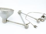 a silver object with a metal spoon and a metal spoon on a white surface