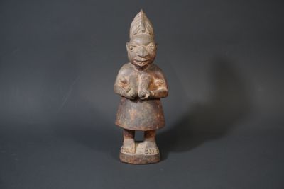 an old wooden statue of a woman holding a flower in her hands