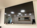 a flat screen tv mounted on the wall above a mirror