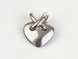 a close up of a silver heart shaped object on a white surface