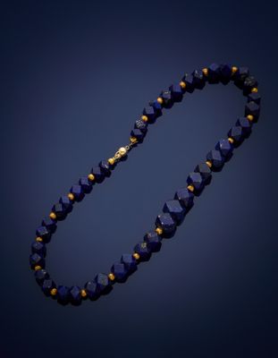 a close up of a blue beaded necklace on a dark background