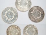 four different types of silver coins on a white surface