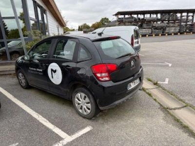 une petite voiture noire garée sur un parking