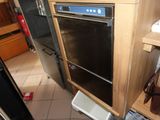 un four noir posé dans une cuisine, à côté d'une poubelle blanche