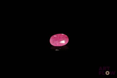 un gros plan d'une pierre rose sur une surface noire