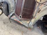 an old car that has been rusted and is sitting on the ground