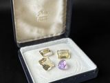 pair of yellow and purple gems in a box on a black surface