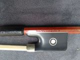 an image of a bow with a wooden handle on a black background