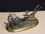a bronze sculpture of a horse drawn carriage on a table