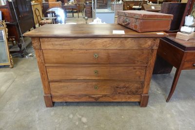 une commode en bois dans une pièce remplie de meubles