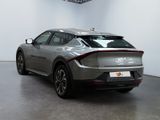 the rear end of a silver sports car parked in a showroom