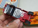 a person holding a red toy truck in front of a box