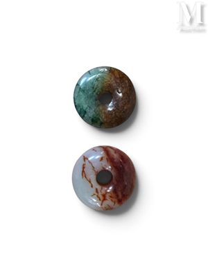 trois beignets de couleurs et de formes différentes posés sur une surface blanche