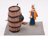 a figurine of a woman standing next to a barrel