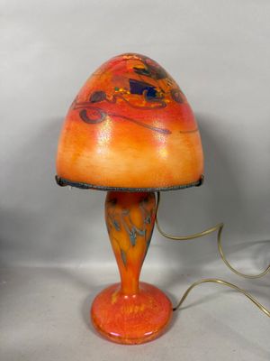 an orange table lamp with a black base and a brown shade