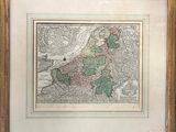 an old map of europe in a gold frame on a wall