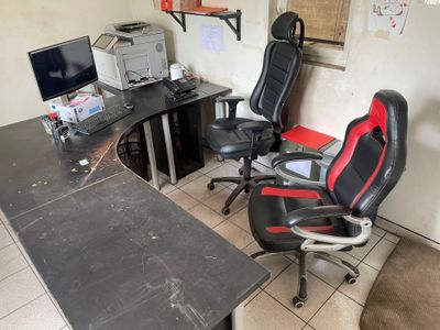 a desk with two chairs and a computer on it