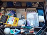 une valise remplie d'objets, posée par terre