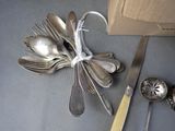 silver spoons and silverware on a table next to a box