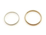 two gold and silver wedding rings on a white background