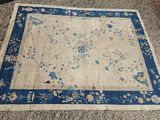 un tapis chinois ancien avec une bordure bleue et un motif floral