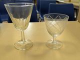two wine glasses sitting on a table next to each other